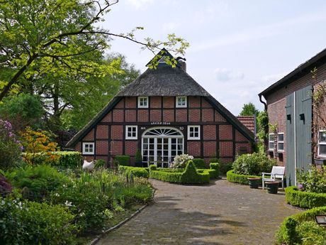 Bauernhaus in Wiefelstede mit Garten im Vordergrund