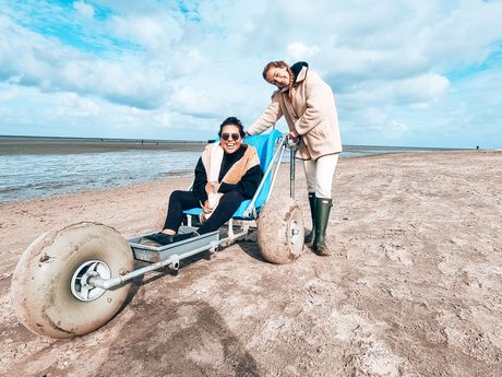 Das Foto zeigt die Bloggerin Kim von Wheeliewanderlust mit ihrer Freundin in einem Wattmobil am Strand
