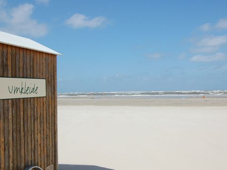 Das Foto zeigt den Strand von Spiekeroog mit einem Badewagen zum Umkleiden