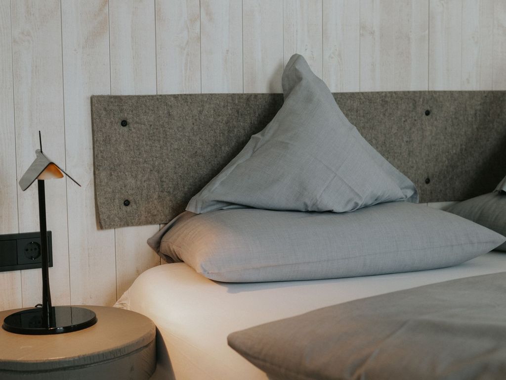 Das Foto zeigt ein gemütliches Bett in einem Hotelzimmer in Ostfriesland