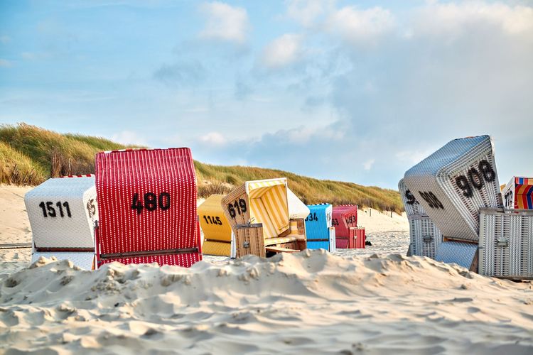 Bunte Strandkörbe im Sand auf Langeoog