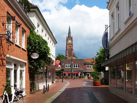Geschäfte in der Innenstadt von Jever mit Stadtkirche im Hintergrund
