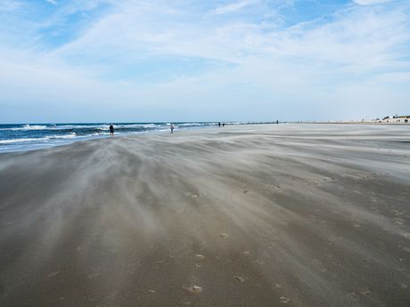 Das Foto zeigt den Strand von Norderney bei starkem Wind und Wellengang