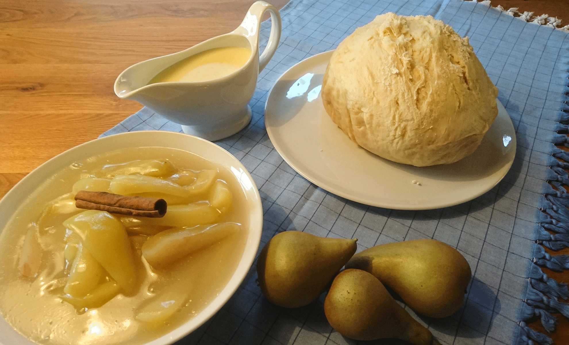 Ein Tisch gedeckt mit einem Puffert, Birnenkompott und Vanillesoße